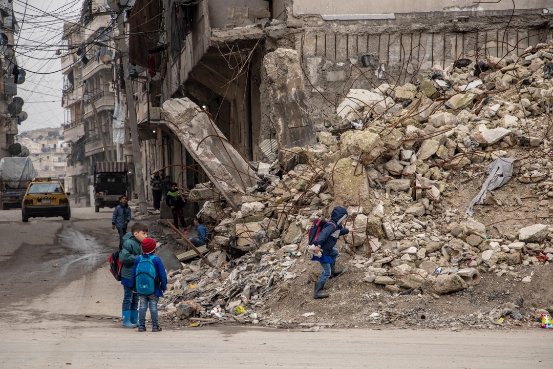 Dei ragazzi raggiungono la scuola aggirando le macerie di Aleppo